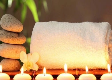 Relaxing spa setup with candles, stones, and towel at The Beauty Lounge, Maputo, Maputo, MZ.