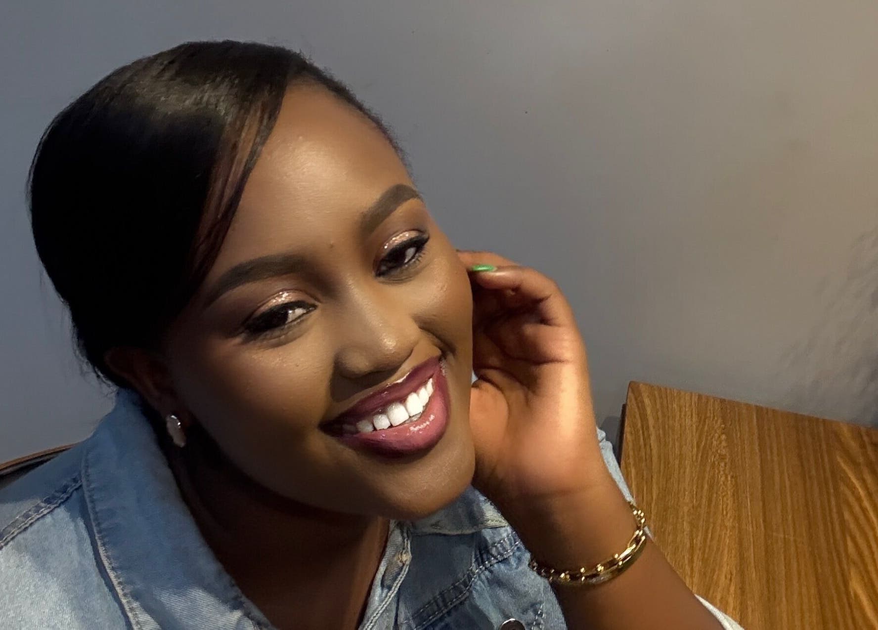 A woman smiling warmly at PALM HOUSE ug, Mulawa, Central Region, UG.