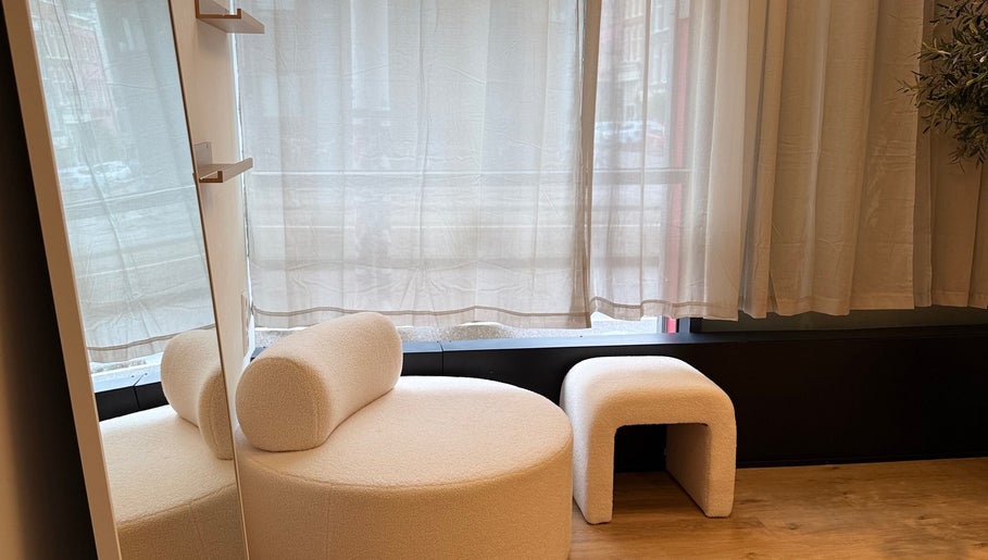 Elegant zitje met spiegel bij Lash’Up in Purmerend, Noord-holland, NL. Moderne en serene setting.