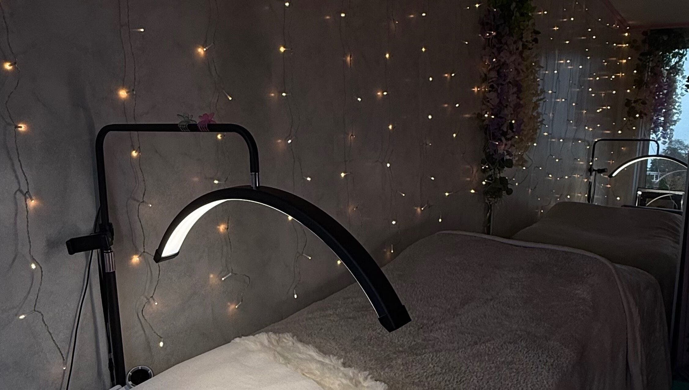 Sfeervol ingerichte salonhoek bij Lash’Up in Purmerend, Noord-holland, NL, met lichtjes en comfortabele behandeltafel.