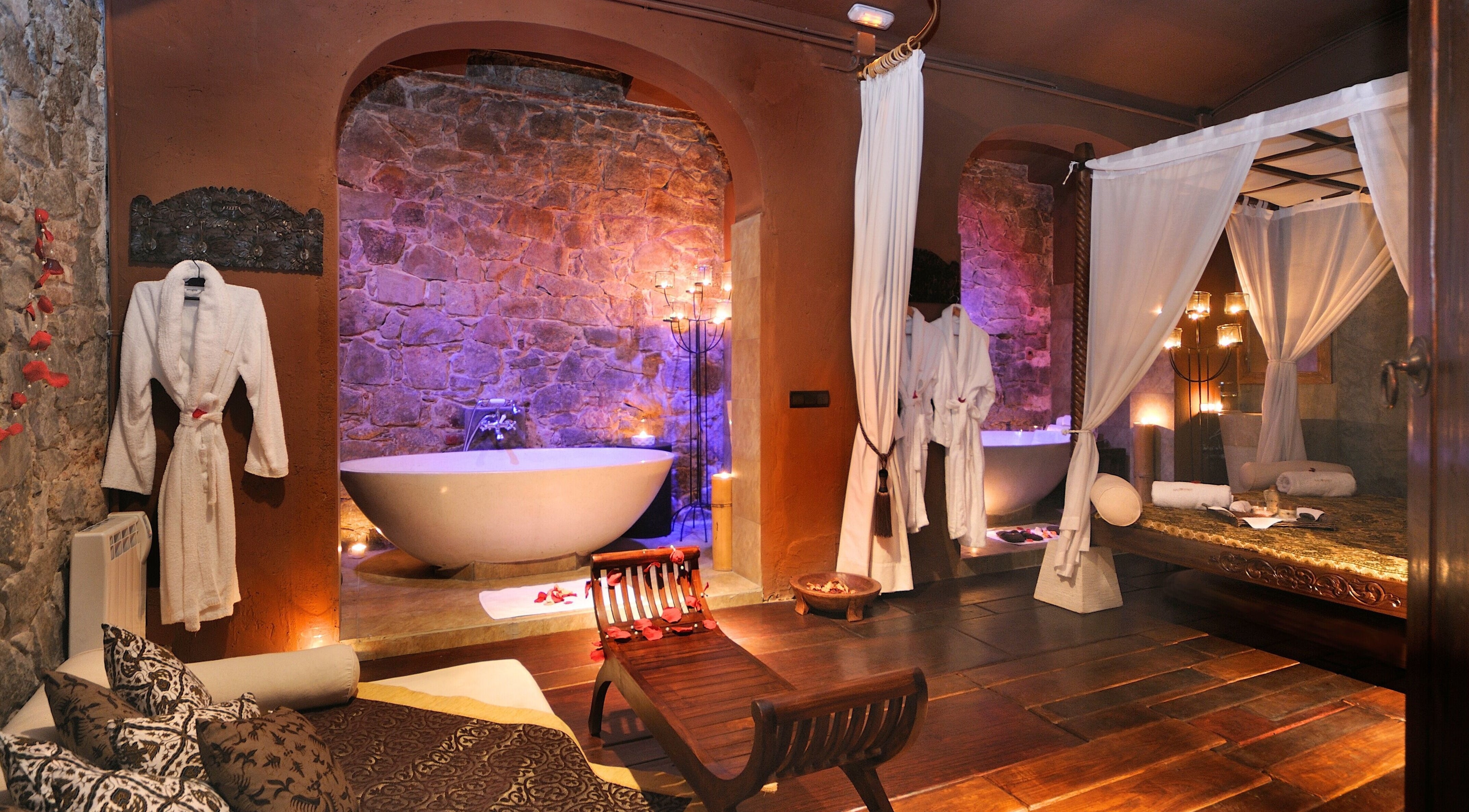 Luxurious spa room at Bali Spirit Luxury Art Spa, Barcelona, Catalunya, ES featuring a stone bath and robes.