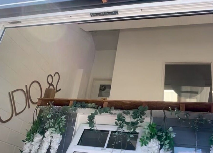 Entrance of JL Beauty in Pontyclun, Wales, GB with 'Studio 82' signage and floral decor.