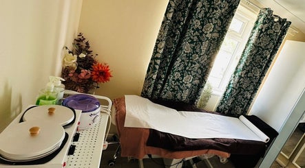 Nudeblush Studio waxing room in Stanwell, England with cozy decor and equipment by a sunlit window.