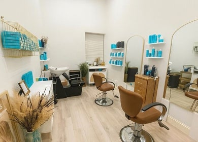 Modern salon interior at Deep Roots Hair Atelier, Riverhead, New York, US with stylish chairs and decor.