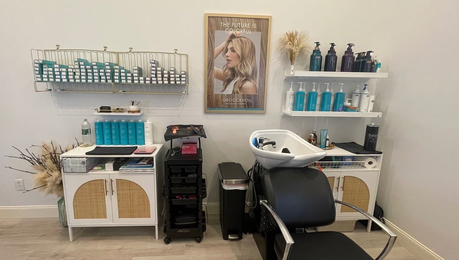Chic salon interior at Deep Roots Hair Atelier, Riverhead, New York, US. Haircare display and modern styling chair.