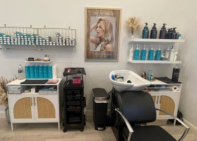 Chic salon interior at Deep Roots Hair Atelier, Riverhead, New York, US. Haircare display and modern styling chair.
