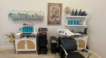 Chic salon interior at Deep Roots Hair Atelier, Riverhead, New York, US. Haircare display and modern styling chair.
