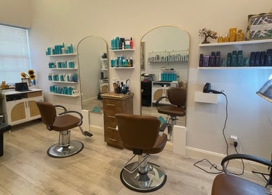 Modern hair studio at Deep Roots Hair Atelier, Riverhead, New York, US with sleek chairs and products on display.
