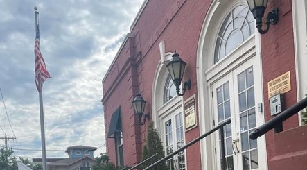 Front view of Deep Roots Hair Atelier located at Riverhead, New York, US, showcasing historic brick facade.