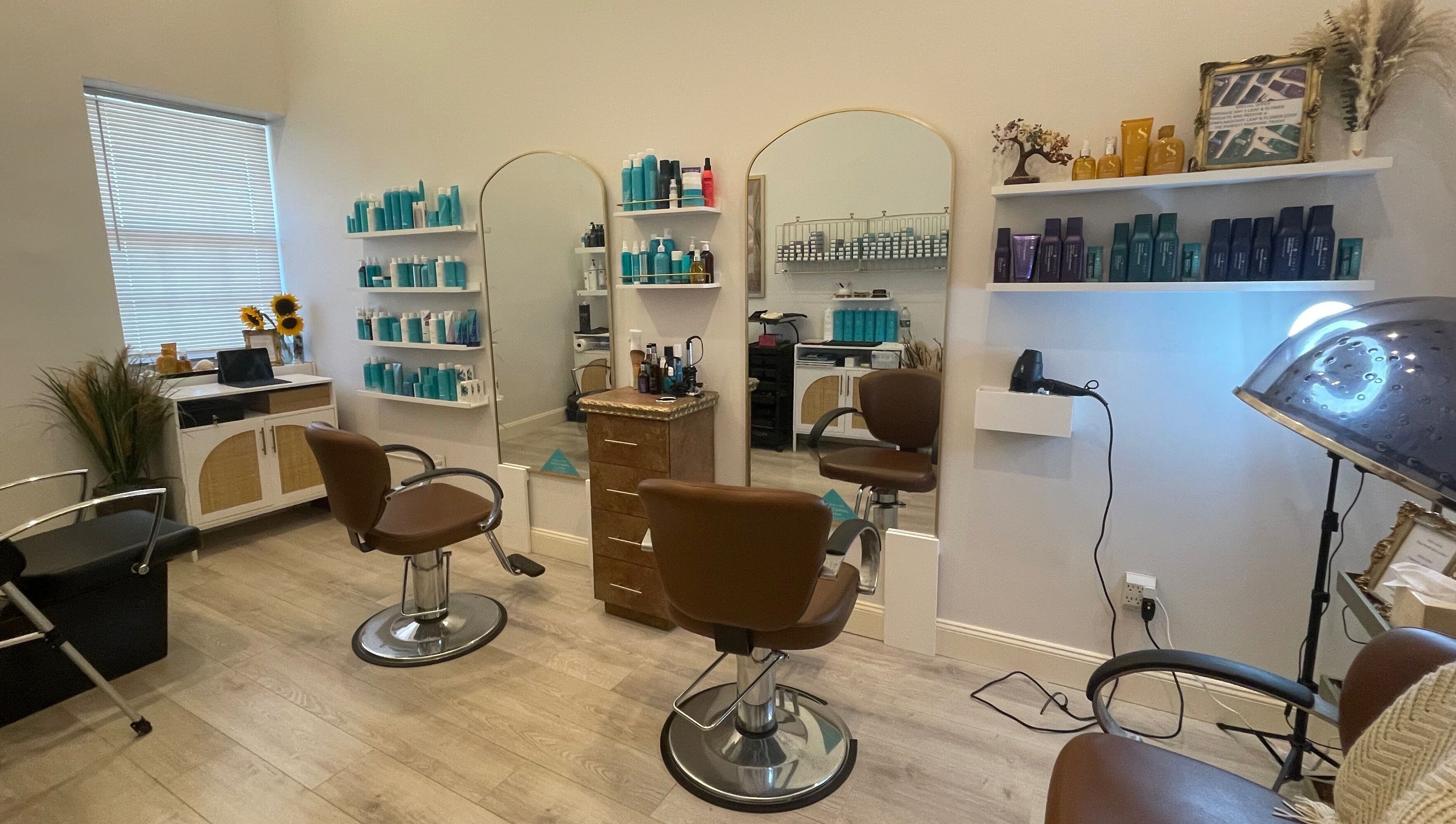 Modern salon interior at Deep Roots Hair Atelier, Riverhead, New York, US with chic chairs and mirrors.