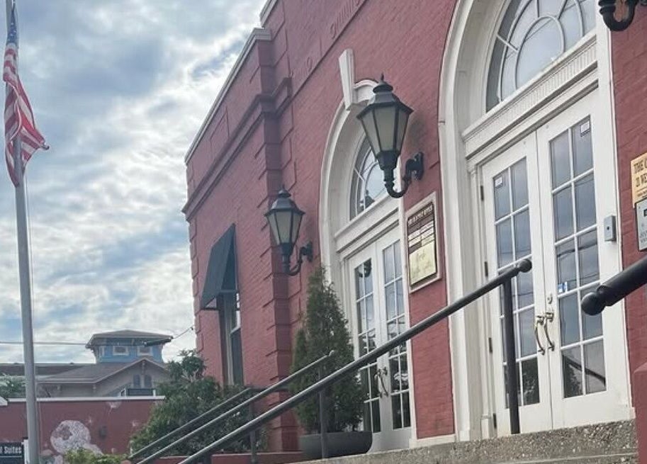 Exterior of Deep Roots Hair Atelier in a historic brick building, Riverhead, New York, US.