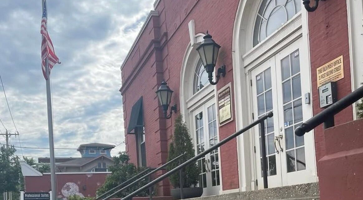 Exterior of Deep Roots Hair Atelier in a historic brick building, Riverhead, New York, US.