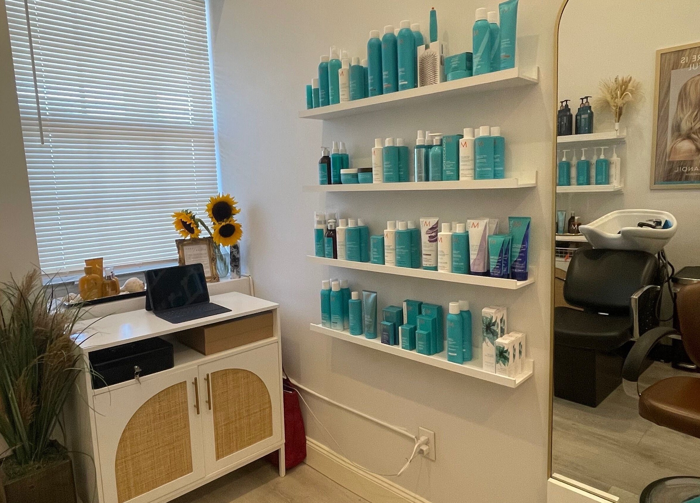 Deep Roots Hair Atelier in Riverhead, New York, US features a sleek salon setup with stylish decor and hair products.