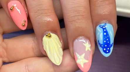 Colorful ocean-themed nail art at Nailsbykeaten, Ames, Illinois, US, featuring starfish and shark designs.