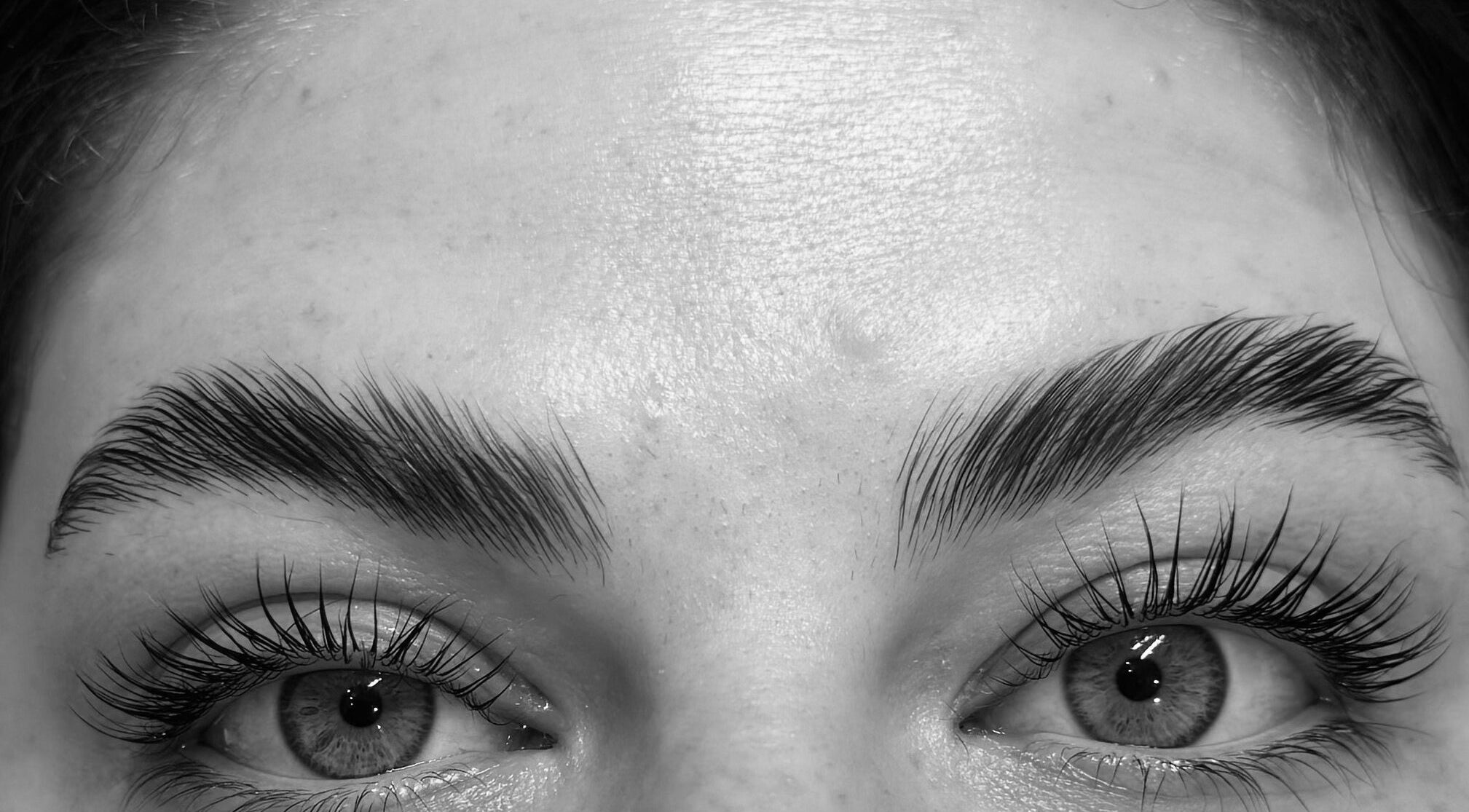 Close-up of perfectly shaped eyebrows and eyelashes by Tynaesthetics_ in London, England, GB.