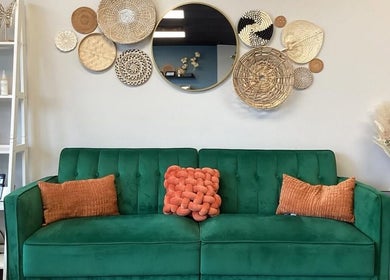 Chic green sofa with decorative pillows at B. Hive Salon, Huntsville, Alabama, US.