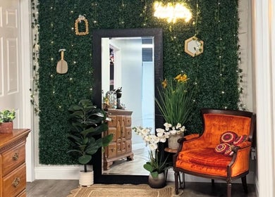 Elegant seating area at B. Hive Salon in Huntsville, Alabama, US with lush greenery and vintage decor.