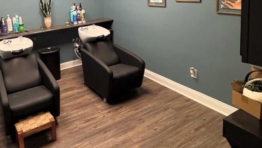 Relaxing wash area at B. Hive Salon, Huntsville, Alabama, US, featuring modern shampoo chairs and serene decor.