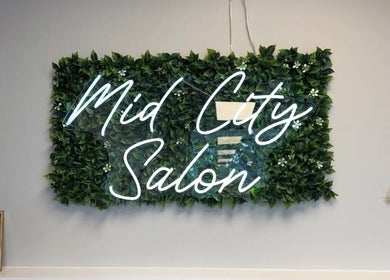 Vibrant green wall with neon sign at B. Hive Salon, Huntsville, Alabama, US.