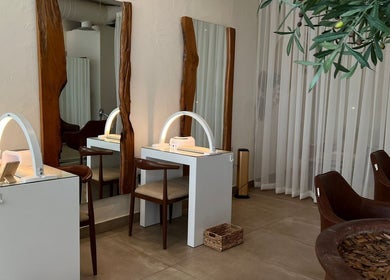 Elegant interior of Be.salon in Riyadh with stylish wooden mirrors and chic seating.