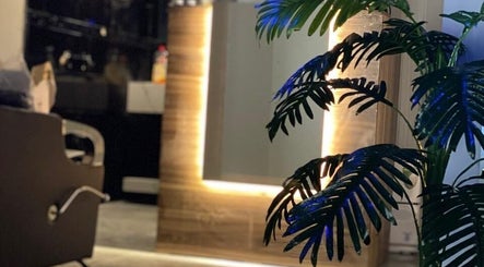 Elegant salon interior at Buzz Stop, Taif, Makkah Province, SA with illuminated mirror and lush plant.