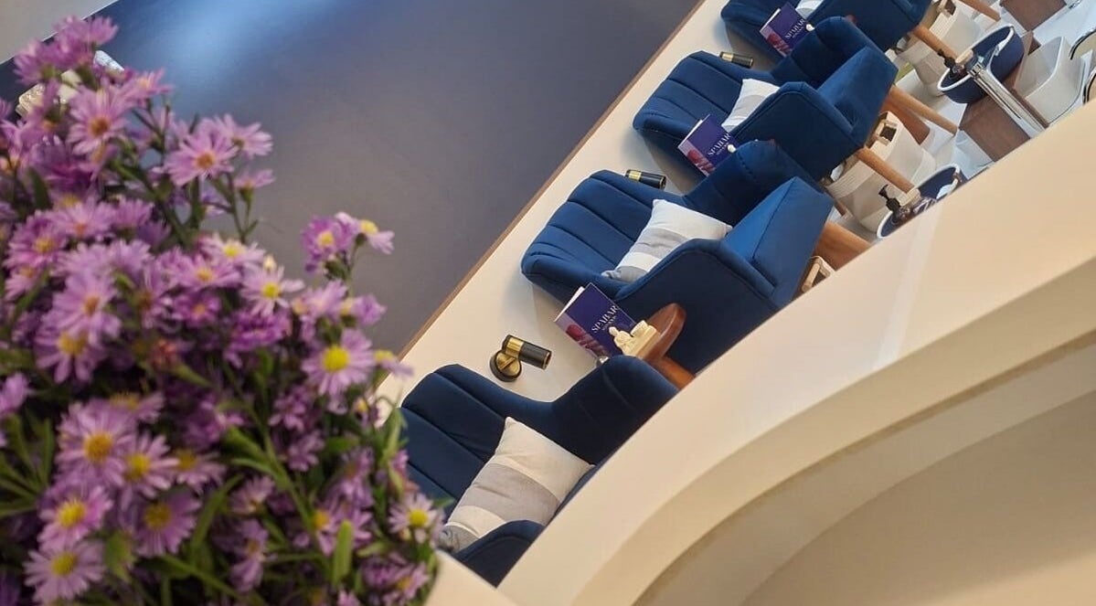 Ambiente relajante en Spabar.ec, Quito, Pichincha, EC, con cómodas sillas azules y flores frescas.