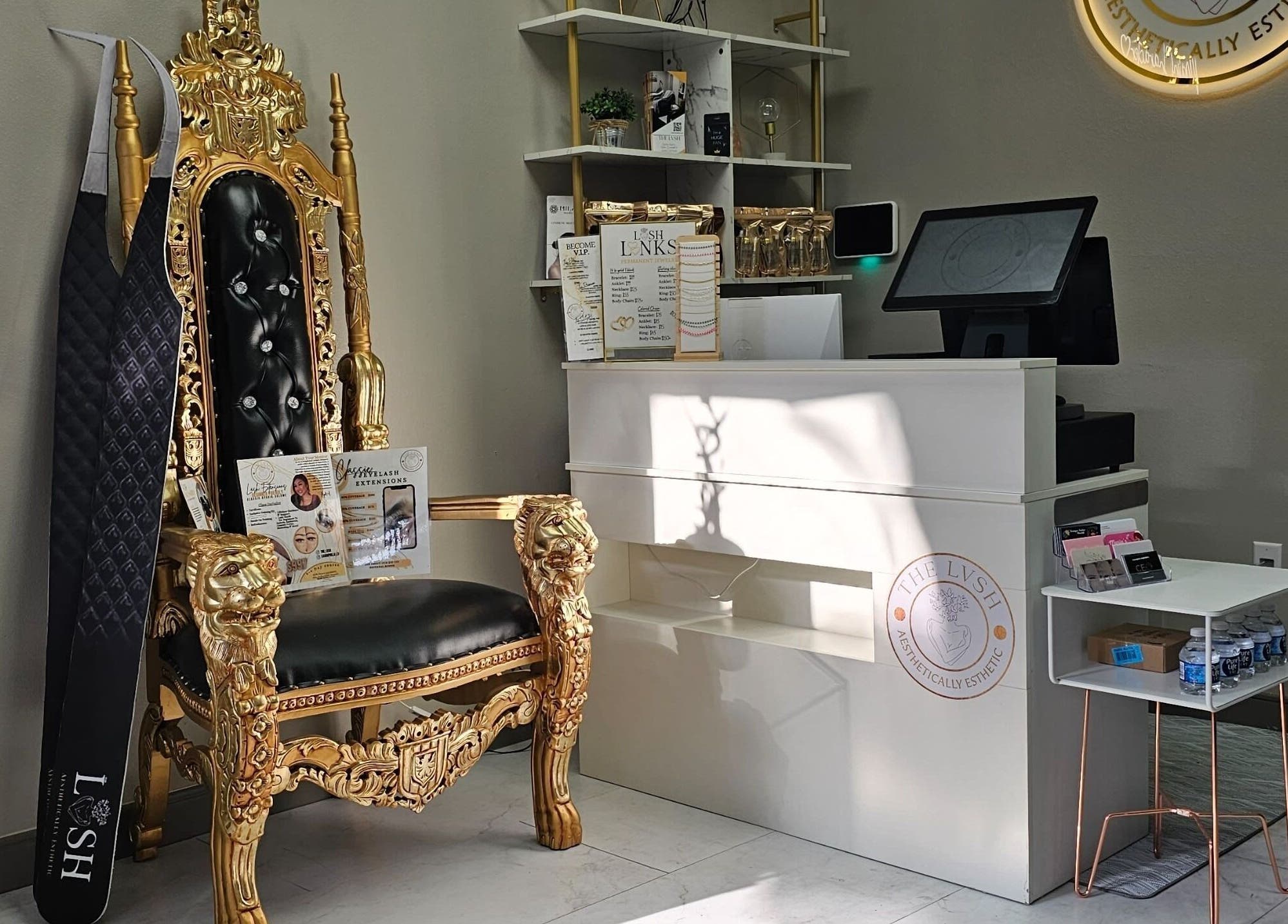 Elegant reception area of The LVSH Salon in Las Vegas, Nevada with a regal chair and gold accents.