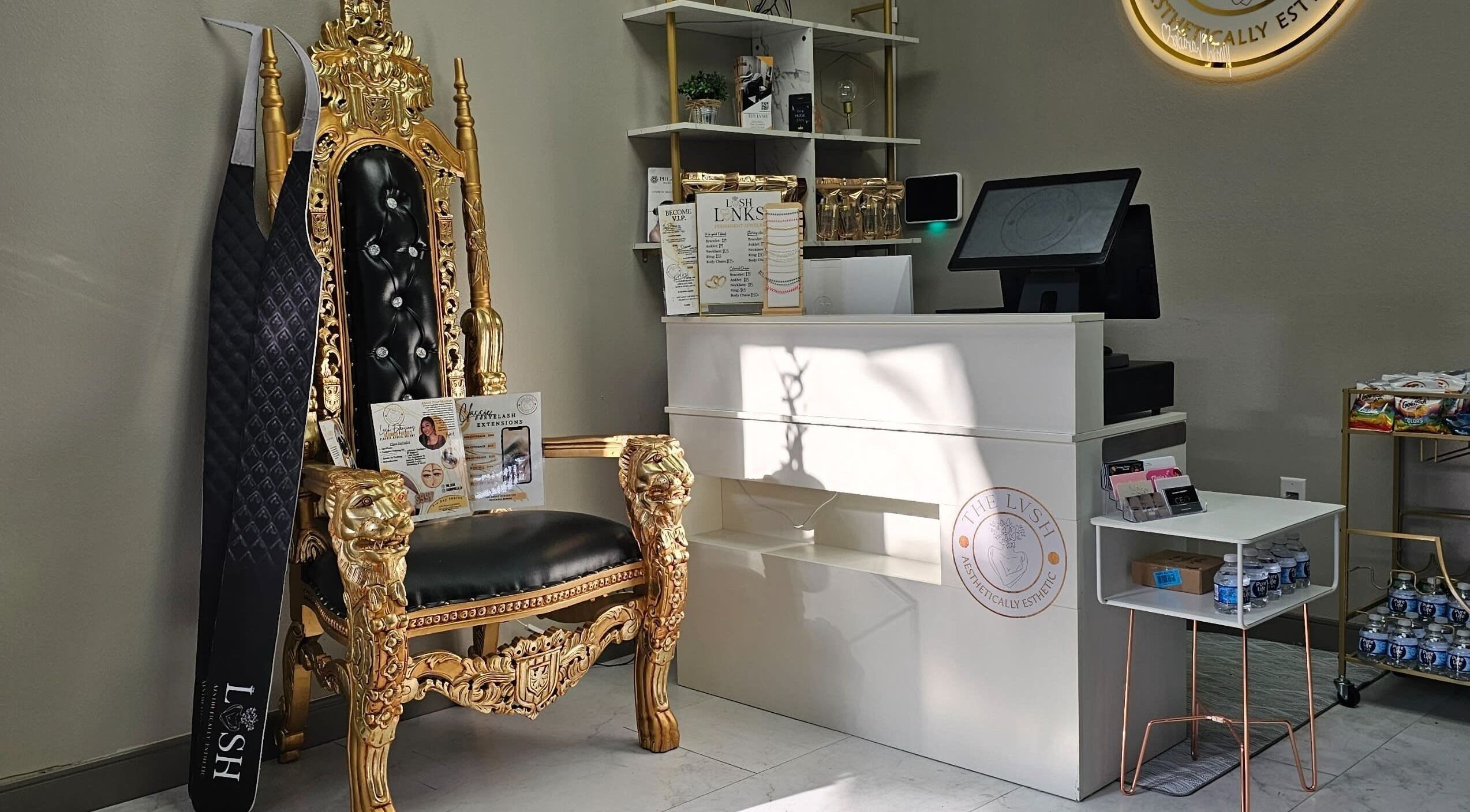 Elegant reception area of The LVSH Salon in Las Vegas, Nevada with a regal chair and gold accents.