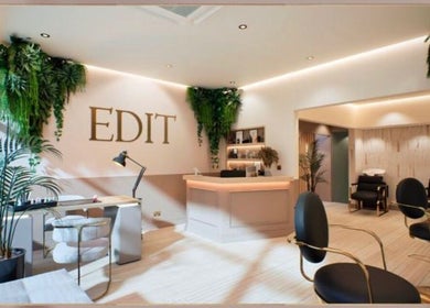 Interior of Hair by Stephanie Shaffi in Birmingham, England, GB. Modern decor with seating and lush greenery.
