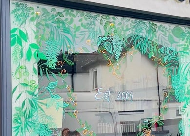 Exterior view of Hair by Stephanie Shaffi in Birmingham, England with green leafy window art.