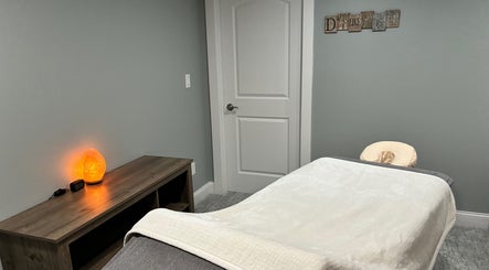 Peaceful massage room at It Is Well, Burlington, Wisconsin, US, featuring a cozy bed and soothing salt lamp.