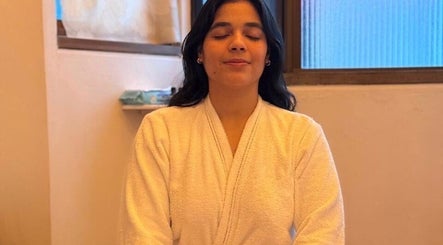 Mujer en meditación con bata en Shalá Wellness Spa, Medellín, Antioquia, CO. Ambiente relajante y sereno.
