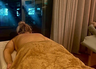Sesión de masaje relajante en Shalá Wellness Spa, Medellín, Antioquia, CO, con vistas a la ciudad iluminada.