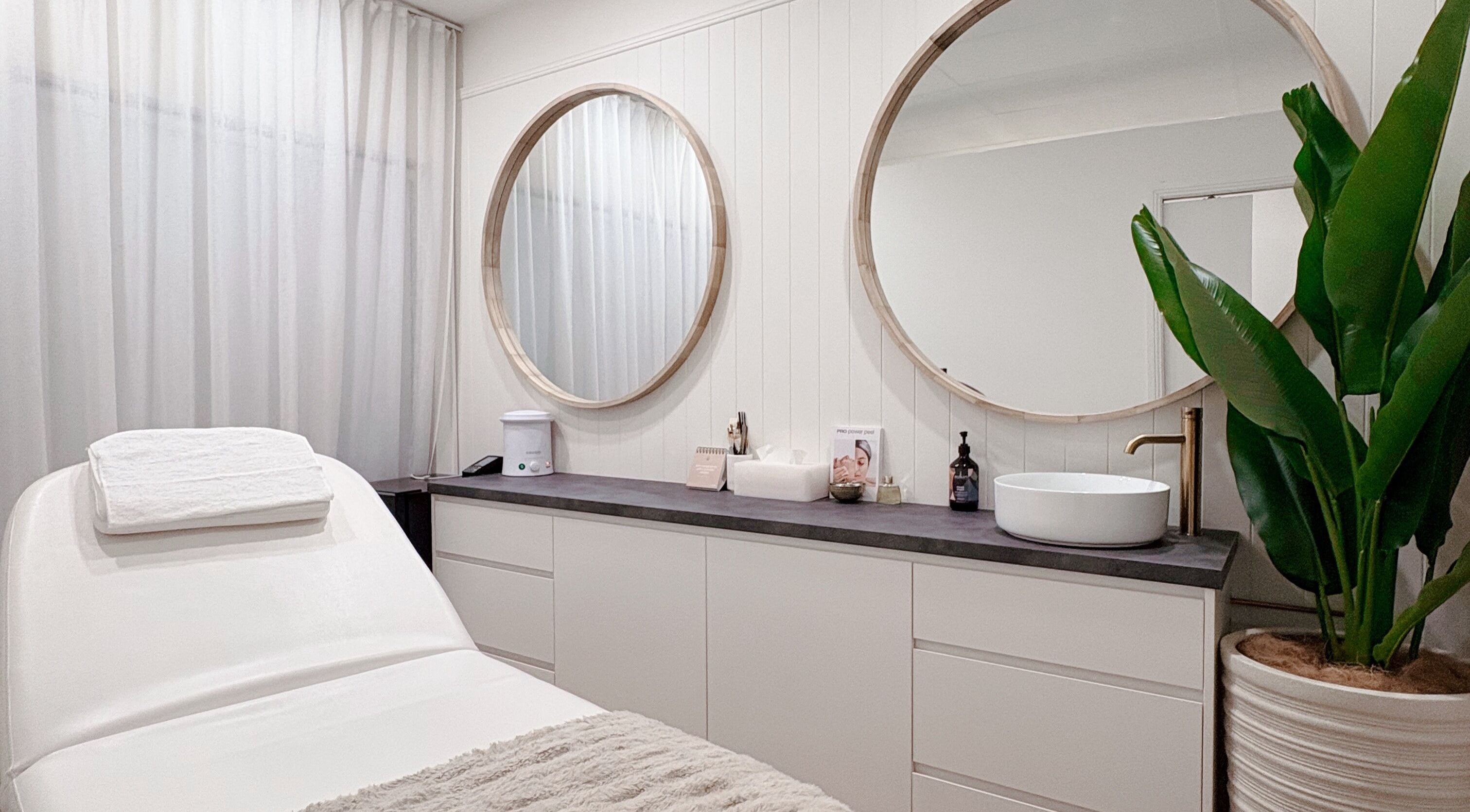 Elegant treatment room at Lashié, Burleigh Heads, Queensland, AU, featuring modern decor and cozy massage bed.