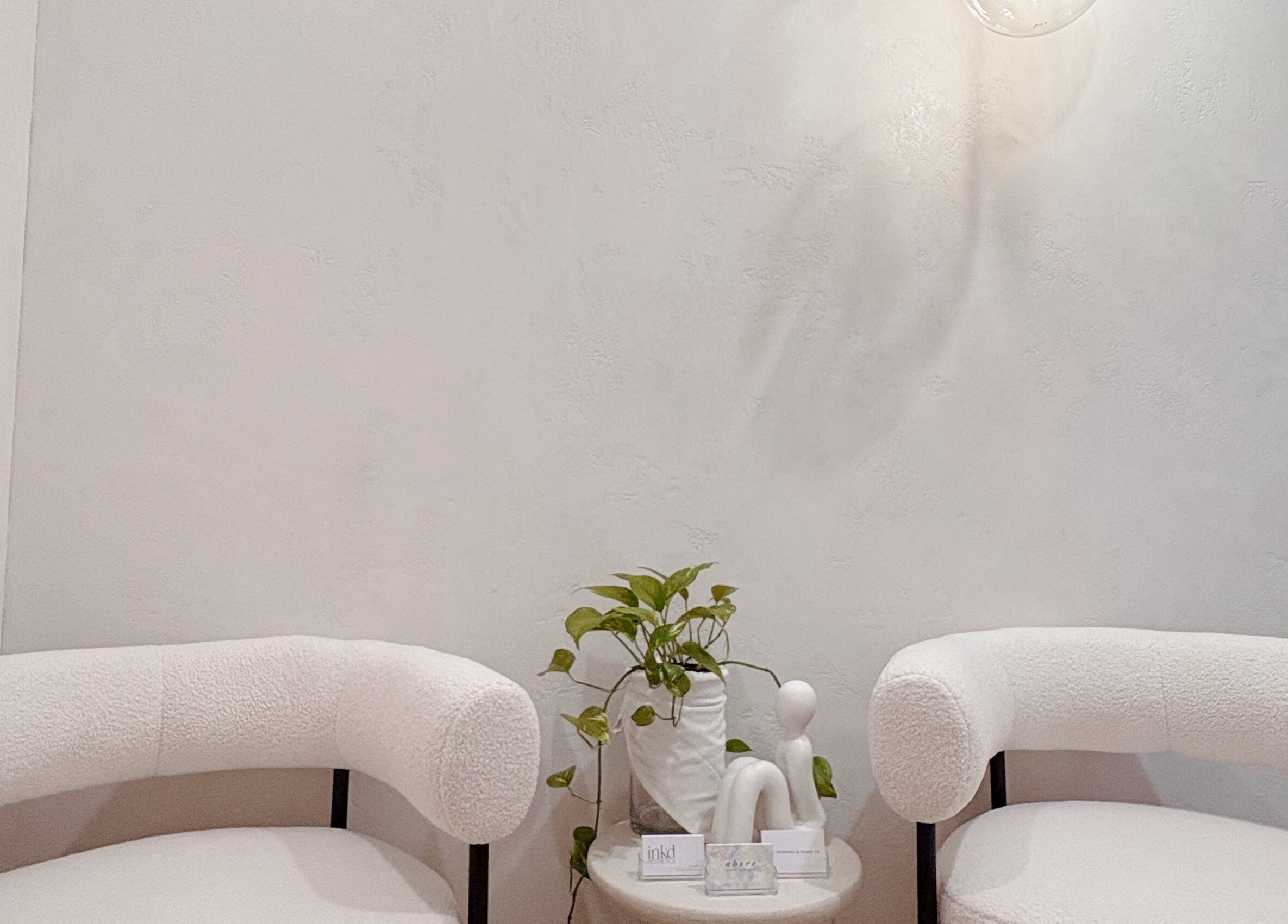 Elegant white chairs and plant in Lashié, Burleigh Heads, Queensland, AU, offering a tranquil setting.