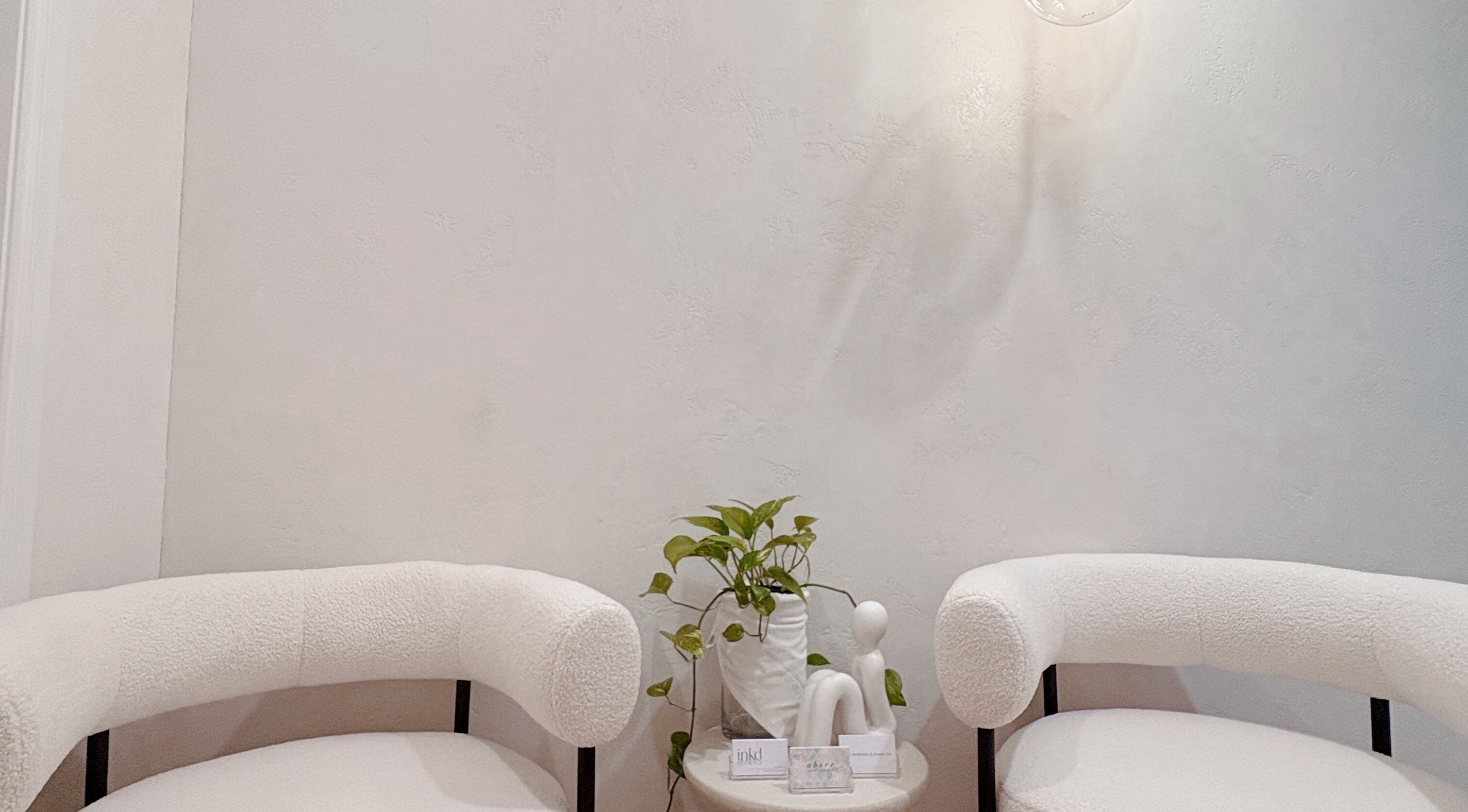 Elegant white chairs and plant in Lashié, Burleigh Heads, Queensland, AU, offering a tranquil setting.