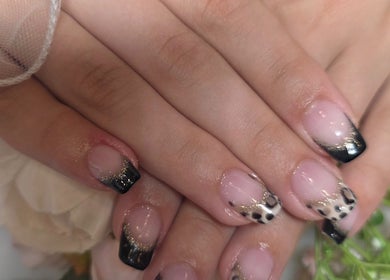 Stylish black and gold manicure at L'amitié, Flemington, New Jersey, US, showcasing nail artistry.