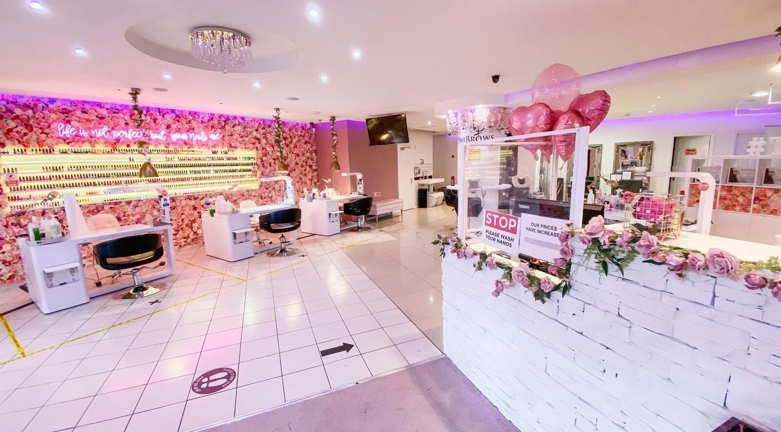 Elegant interior of The Nails Boutique in Kingston Upon Thames, England, GB with chic floral decor and modern stations.