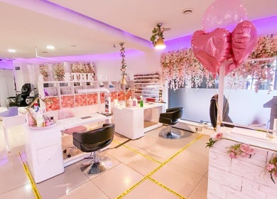 Chic interior of The Nails Boutique in Kingston Upon Thames, featuring floral decor and pink themed seating.