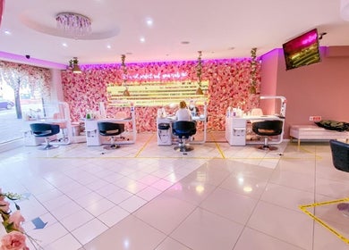 Chic interior of The Nails Boutique in Kingston Upon Thames, England, GB with floral decor and manicure stations.