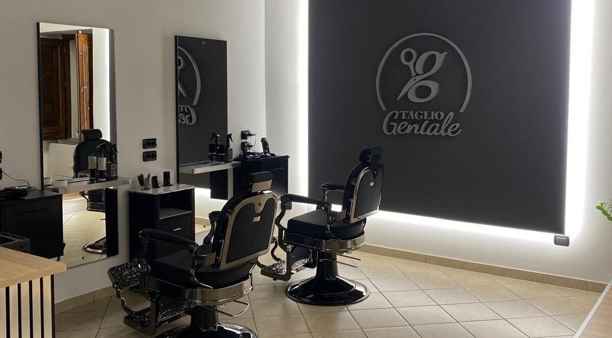 Interno sofisticato di Taglio Geniale, Parenti, Calabria, IT con sedie da barbiere moderne e specchi eleganti.