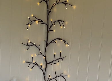 Illuminated branch wall decor at Nails By Gracie, Swindon, England, GB adds a warm ambiance.