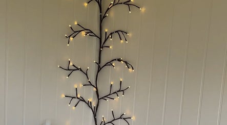 Illuminated branch wall decor at Nails By Gracie, Swindon, England, GB adds a warm ambiance.