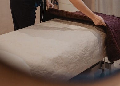 Therapist preparing massage table at Pure Day Spa, Kerikeri, Northland, NZ for a soothing treatment.