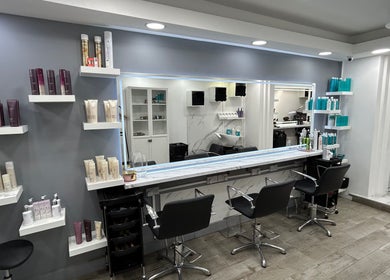 Elegant styling area in The Royal salon, London, England, GB with modern chairs and hair products.