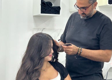 Stylist perfecting hair at The Royal Salon, London, England, GB. A serene beauty experience.