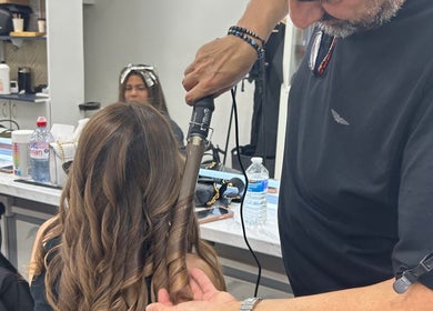 A hair stylist curls a client's hair at The Royal Salon in London, England, GB.
