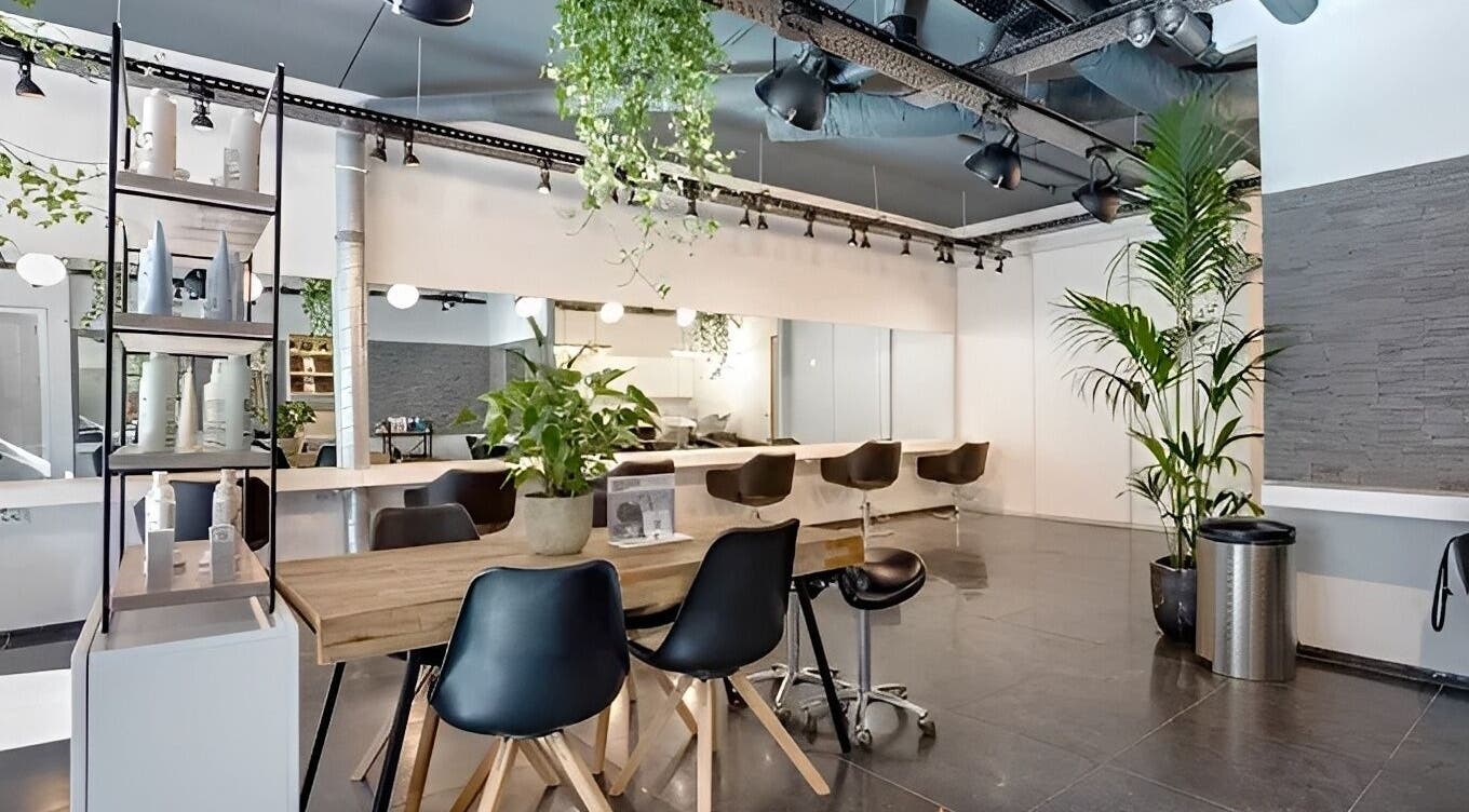 Современный интерьер салона HairbyNastia в Амстердаме, Noord-Holland, NL с элегантной мебелью и зеленью.