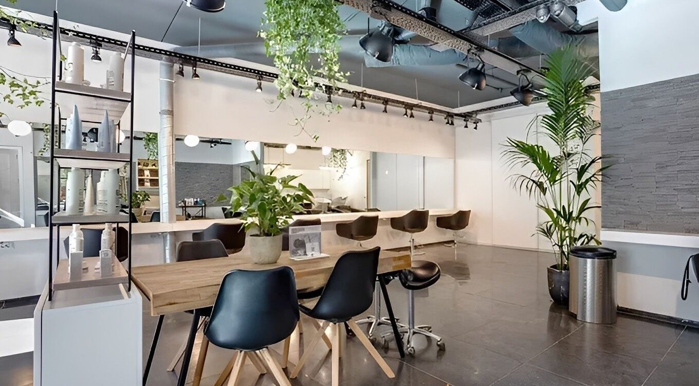 Современный интерьер салона HairbyNastia в Амстердаме, Noord-Holland, NL с элегантной мебелью и зеленью.