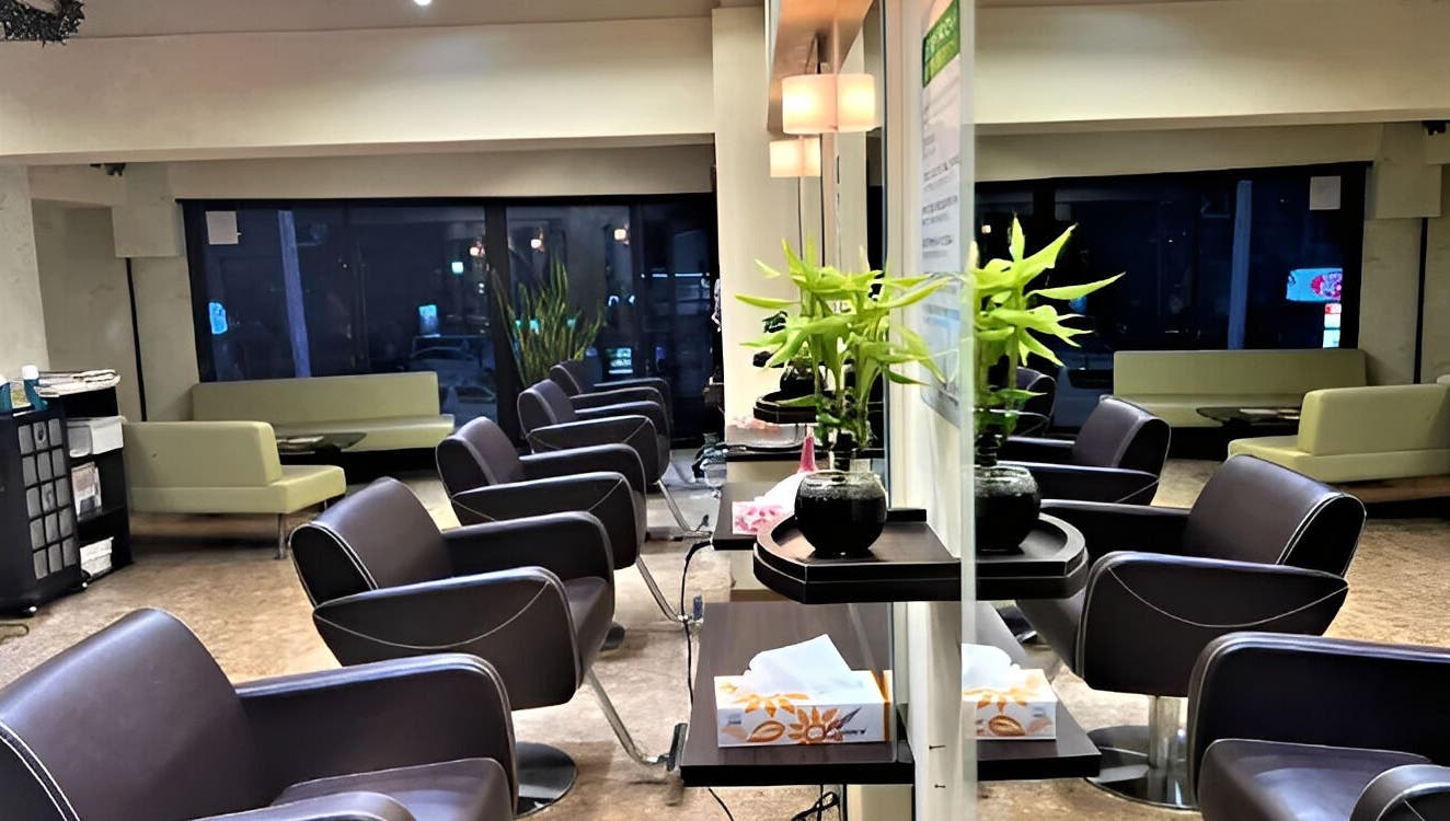 Modern interior of パリ美容室 in Shinjuku City, Tokyo, JP, showing sleek chairs and elegant decor.